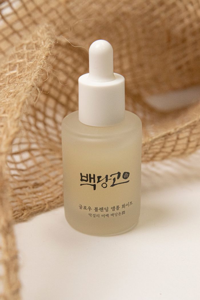 A minimalist glass serum bottle with Korean text, ideal for skincare product photography.